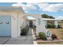 Close-up of the home's front entrance with a decorative gate, archway, and a seahorse wall decoration at 953 Tropical Nw Ave, Port Charlotte, FL 33948
