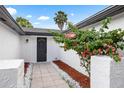 Charming walkway to the front door with red bark and white gravel landscaping plus flowering bougainvillea at 9831 Scenic Dr, Port Richey, FL 34668