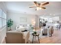 Bright and airy living room with hardwood floors, modern furnishings, and a ceiling fan with a view to the kitchen at 9929 Bay Dr, Gibsonton, FL 33534
