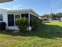 Well-maintained backyard with a screened-in lanai and lush green lawn, offering a private outdoor space at 10169 45Th N St, Pinellas Park, FL 33782