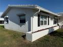 Bright exterior view of home with white stucco, tidy landscaping, and window shutters at 10169 45Th N St, Pinellas Park, FL 33782