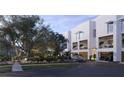 Modern condo exterior featuring garage parking, manicured landscaping, and private balconies at 1028 Sunset Point Rd # R4, Clearwater, FL 33755