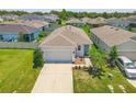 Aerial view of a well-maintained single-story home with a two-car garage, manicured lawn, and beautiful landscaping at 10945 High Noon Trl, Parrish, FL 34219