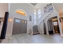 Grand entryway with soaring ceilings, unique light fixtures, elegant staircase, and stylish gray-toned floors at 1156 2Nd S Ave, Tierra Verde, FL 33715