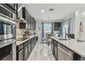 Modern kitchen featuring sleek black cabinets, stainless steel appliances and decorative backsplash at 11602 Sunburst Marble Rd, Riverview, FL 33579