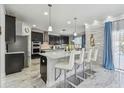 Modern kitchen with stainless steel appliances, black cabinets, stone accent wall and stylish bar stool seating at 11602 Sunburst Marble Rd, Riverview, FL 33579