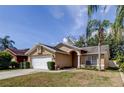 Inviting single-story home featuring a two-car garage, landscaped front yard, and neutral stucco exterior at 11641 Branch Mooring Dr, Tampa, FL 33635