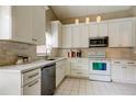 Bright kitchen featuring white cabinets, stainless steel appliances, and tile backsplash at 11641 Branch Mooring Dr, Tampa, FL 33635