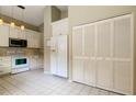 Well-lit kitchen equipped with appliances, ample storage, and pristine tile floors at 11641 Branch Mooring Dr, Tampa, FL 33635