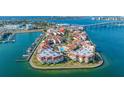 Aerial view showcases waterfront condos, a marina, a pool, and lush landscaping by the bay at 120 1St E St # 109, Tierra Verde, FL 33715