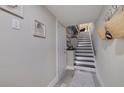 Hallway leading to stairs features white-painted walls, modern wall art, and wood-look floors at 120 1St E St # 109, Tierra Verde, FL 33715