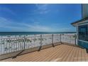 Spacious wooden deck with white railing offers stunning views of the ocean and beach at 13303 Gulf Ln, Madeira Beach, FL 33708