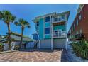 Beautiful turquoise beach house featuring multiple balconies and a two-car garage at 13303 Gulf Ln, Madeira Beach, FL 33708