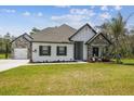 Beautiful single-story home featuring stone accents, a well-manicured lawn, and a welcoming entrance at 13334 Oldenburg Dr, Hudson, FL 34667