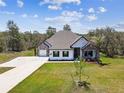 Charming single-Gathering home featuring stone accents, dark shutters, a well-manicured lawn, and an attached two-car garage at 13334 Oldenburg Dr, Hudson, FL 34667