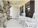 Inviting porch with white rocking chairs, stone accents, and a relaxing atmosphere at 13334 Oldenburg Dr, Hudson, FL 34667