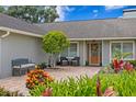 Inviting front entrance with brick patio, bench, and vibrant landscaping offers a warm welcome at 13810 Lake Village Pl, Tampa, FL 33618