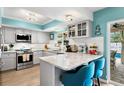 Modern kitchen featuring stainless steel appliances, granite countertops, and stylish breakfast bar at 13810 Lake Village Pl, Tampa, FL 33618