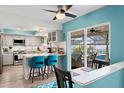 Bright kitchen with eat-in bar area, stainless appliances, and view of screened pool and patio at 13810 Lake Village Pl, Tampa, FL 33618