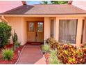 Home featuring a brick path, lush landscaping, and elegant double doors with decorative glass windows at 13903 Wolcott Dr, Tampa, FL 33624