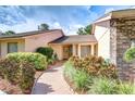 Brick walkway leads to a quaint entrance with natural wood double doors and verdant landscaping at 13903 Wolcott Dr, Tampa, FL 33624