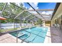 A screened-in pool area features a sparkling in-ground pool and hot tub, perfect for entertaining at 13903 Wolcott Dr, Tampa, FL 33624