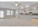 Open-concept living and kitchen area with tiled floors in the kitchen and white cabinets at 16137 Churchview Dr, Lithia, FL 33547