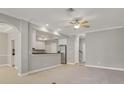 Spacious living room showing open floor plan flowing into kitchen with stainless steel appliances at 16137 Churchview Dr, Lithia, FL 33547