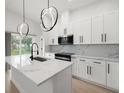 Well-lit kitchen with white cabinets, marble countertops, and a modern faucet at 1625 39Th S St, St Petersburg, FL 33711