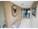 Tiled hallway with mirror, bench, and an open concept living space at 1846 Golfview Dr # 1846, Tarpon Springs, FL 34689