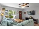 Comfortable living room with a cozy blue sectional couch, TV, hardwood floors, and a bright window at 2136 Cunningham Dr, Clearwater, FL 33763