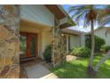 Inviting front entrance with decorative glass doors, stone accents, and lush landscaping, creating a warm welcome at 313 Oak Crest Dr, Safety Harbor, FL 34695