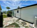 Side of the mobile home with a small garden area and a concrete patio at 34041 Azalea N Dr, Pinellas Park, FL 33781