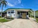 Mobile home with a covered carport showcasing the front facade and landscaping at 34041 Azalea N Dr, Pinellas Park, FL 33781