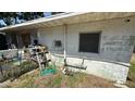 Exterior of property featuring weathered siding, exposed pipes, and a window with security bars, highlighting renovation potential at 3424 16Th E St, Bradenton, FL 34208