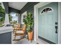 Inviting front porch with rocking chairs, potted plant and stylish door of the gray, two-story home at 4205 N Suwanee Ave, Tampa, FL 33603
