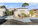 Charming townhome featuring a unique tree overhanging, stone walkway, and neutral paint scheme at 4309 Cedar Grove St, Holiday, FL 34691