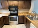 This kitchen features wood cabinets, modern stainless steel appliances, and tile floors at 4309 Cedar Grove St, Holiday, FL 34691
