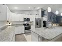 Bright, open kitchen features white cabinets, granite countertops, and stainless-steel appliances at 5153 Bayley St, North Port, FL 34288