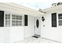 Close-up of the front door, white brick, and black shutters at 6508 Lenore Dr, Tampa, FL 33634