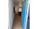 Inviting entryway with a bright blue door, light wood floors, and decorative wall paneling at 6527 S West Shore Cir, Tampa, FL 33616