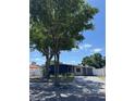 An exterior view of a charming home with mature trees in a well-maintained front yard at 6527 S West Shore Cir, Tampa, FL 33616