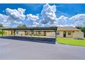 Exterior view under carport highlighting the property's proximity to parking and well-kept landscaping at 6550 Teak Ct, Zephyrhills, FL 33542