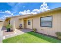 Charming front entrance with lush green lawn, decorative plants and seating area at 6550 Teak Ct, Zephyrhills, FL 33542
