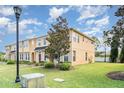 Townhome exterior with neat lawn, sidewalk and beautiful landscaping with a light pole at 6920 Towering Spruce Dr, Riverview, FL 33578