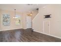 Bright living room with dark floors, an entry door and a stairway to the upper level at 6920 Towering Spruce Dr, Riverview, FL 33578