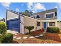 Charming two-story home with a blue garage door and turquoise front door at 7318 Bellows Falls Ln, Hudson, FL 34667