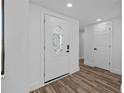 Bright foyer featuring a decorative glass front door and wood-look flooring at 7318 Bellows Falls Ln, Hudson, FL 34667