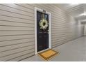 Condominium front door with wreath and neutral colored siding at 800 S Dakota Ave # 204, Tampa, FL 33606