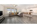 Open-concept living space with sleek tile floors, modern furnishings, and abundant natural light at 8719 Winning Fields Rd, New Port Richey, FL 34655